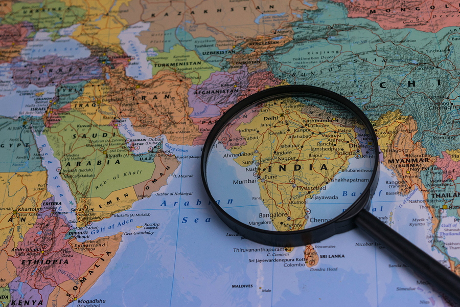 India map through magnifying glass on a world map