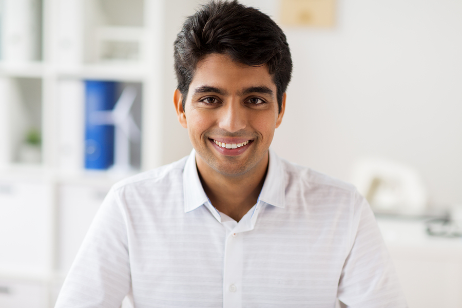 business and people concept - smiling indian businessman at office